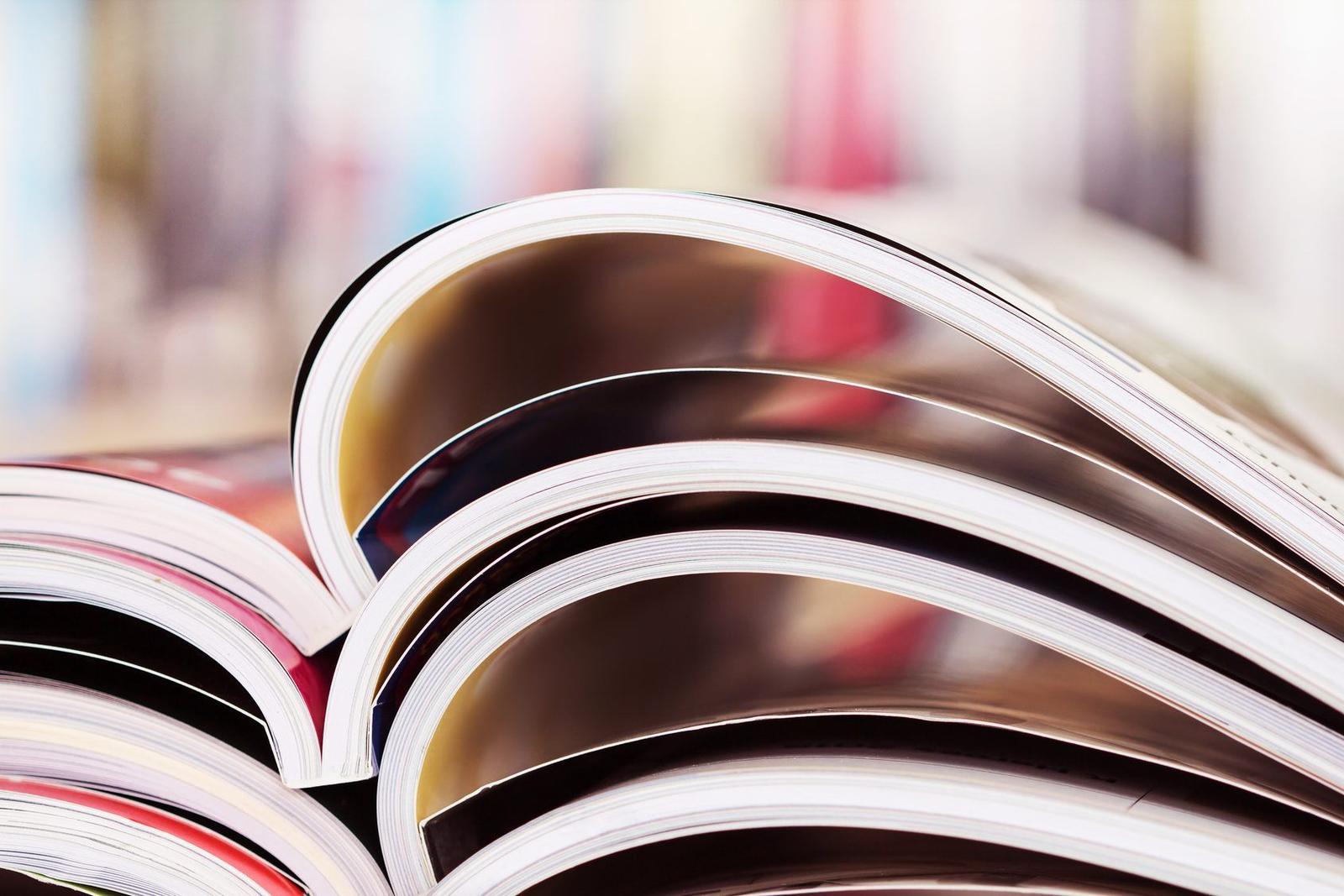 A stack of printed magazines and reports