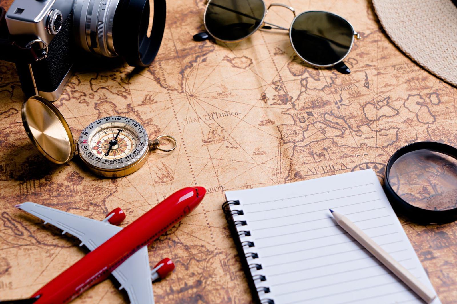 A map, compass and passport-style travel kit laid out for a journey
