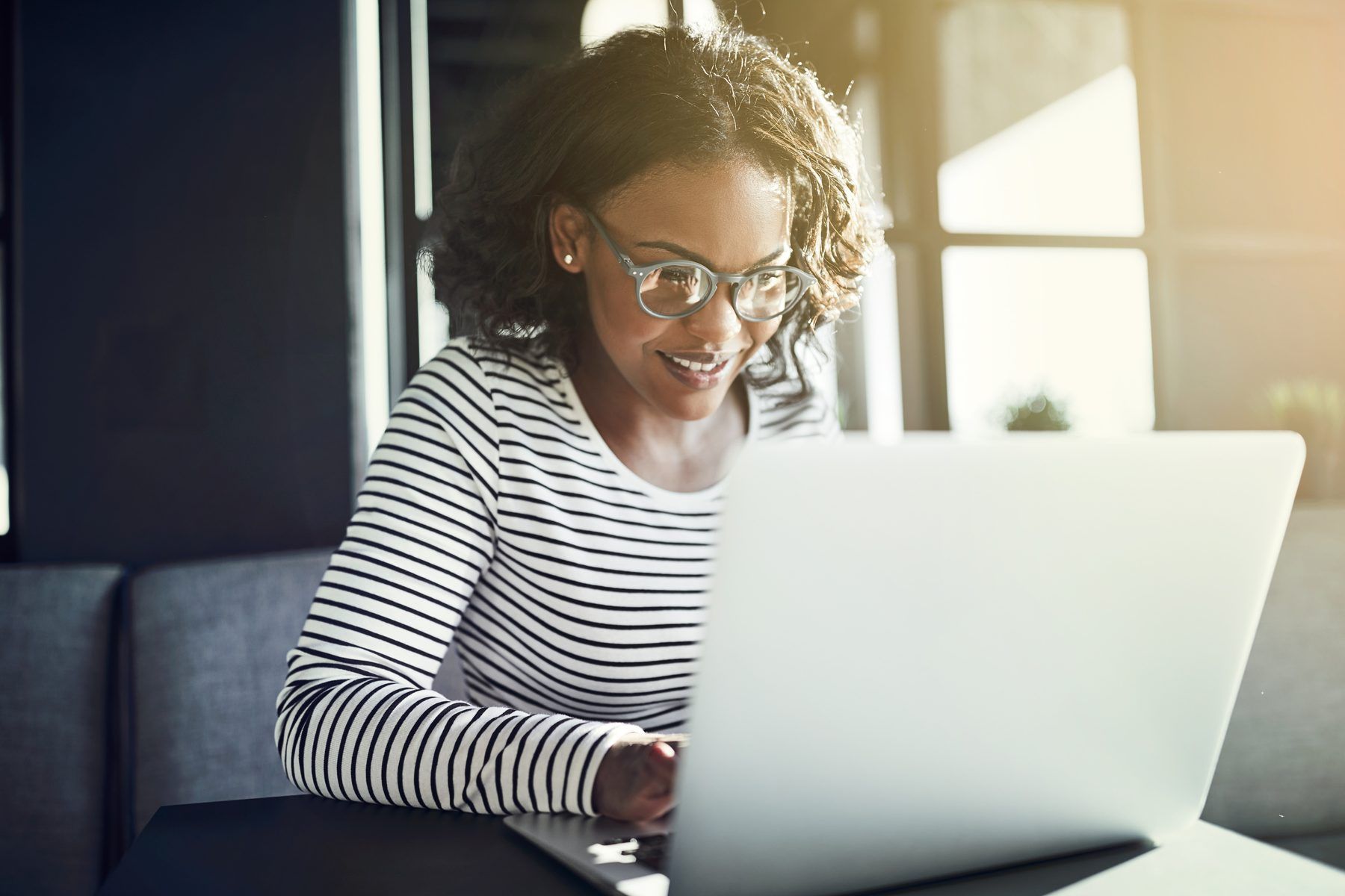 A smiling woman working on her laptop