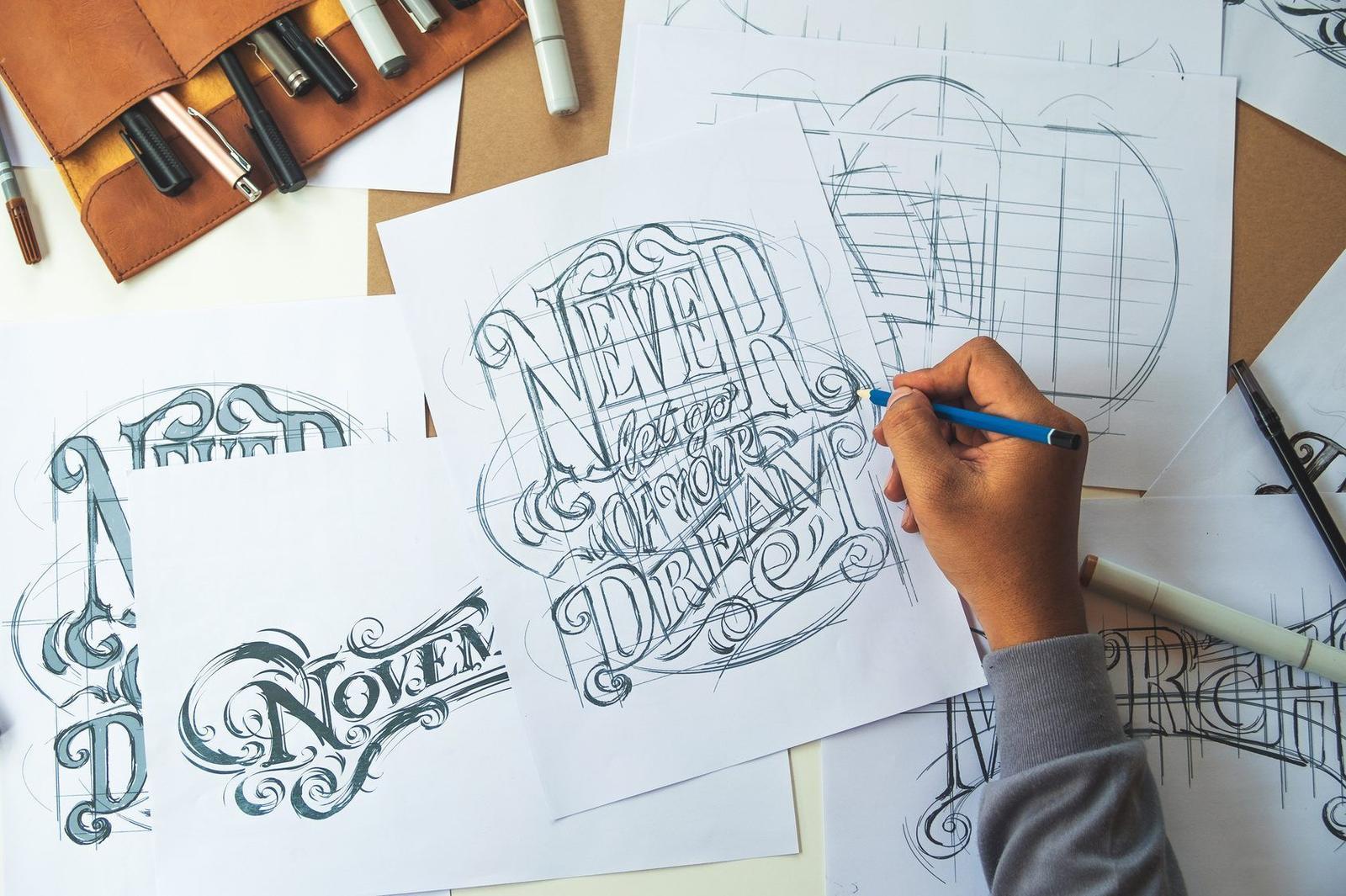 A designer sketching logo ideas in a notebook