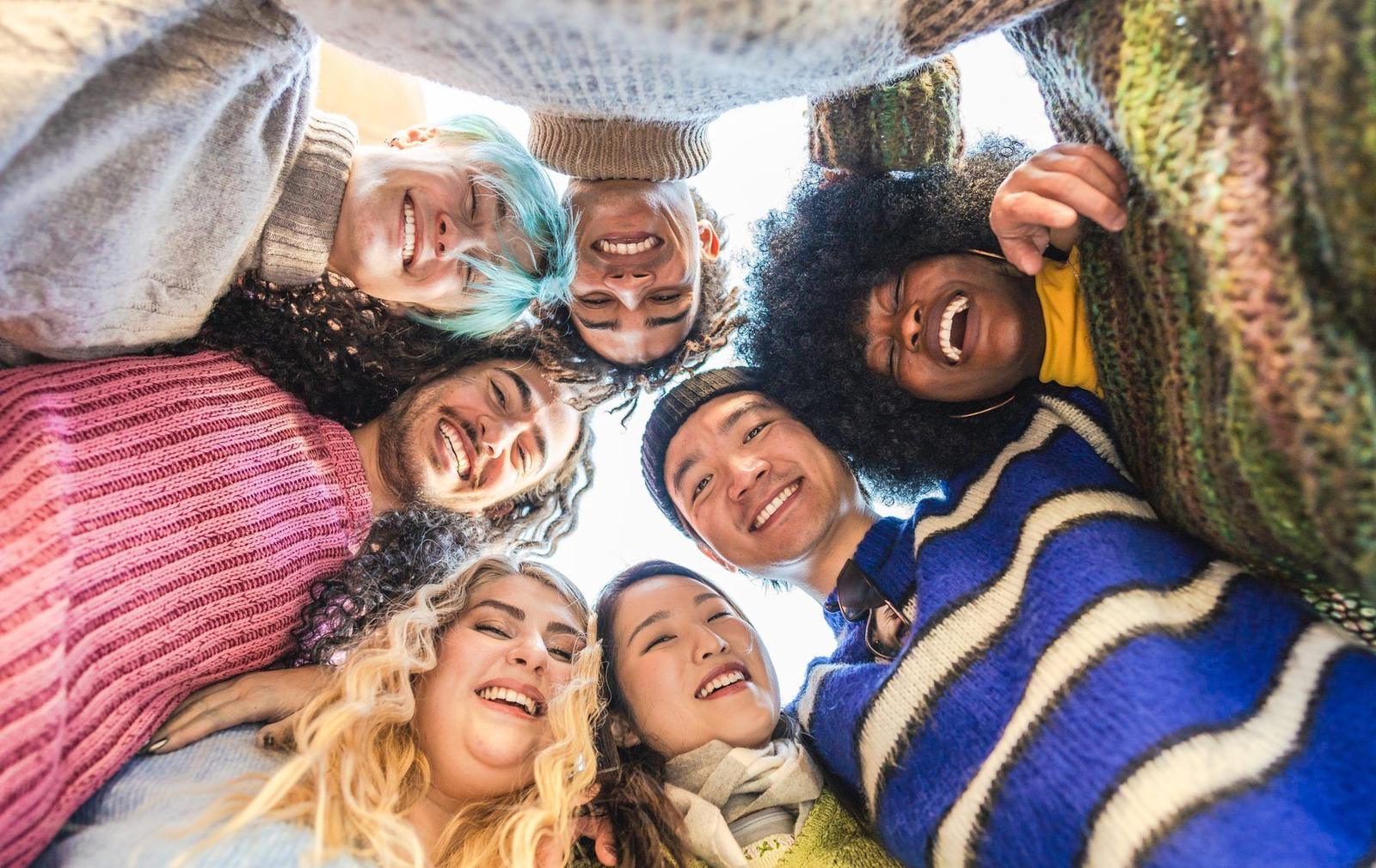 A diverse group of friends smiling in a circle