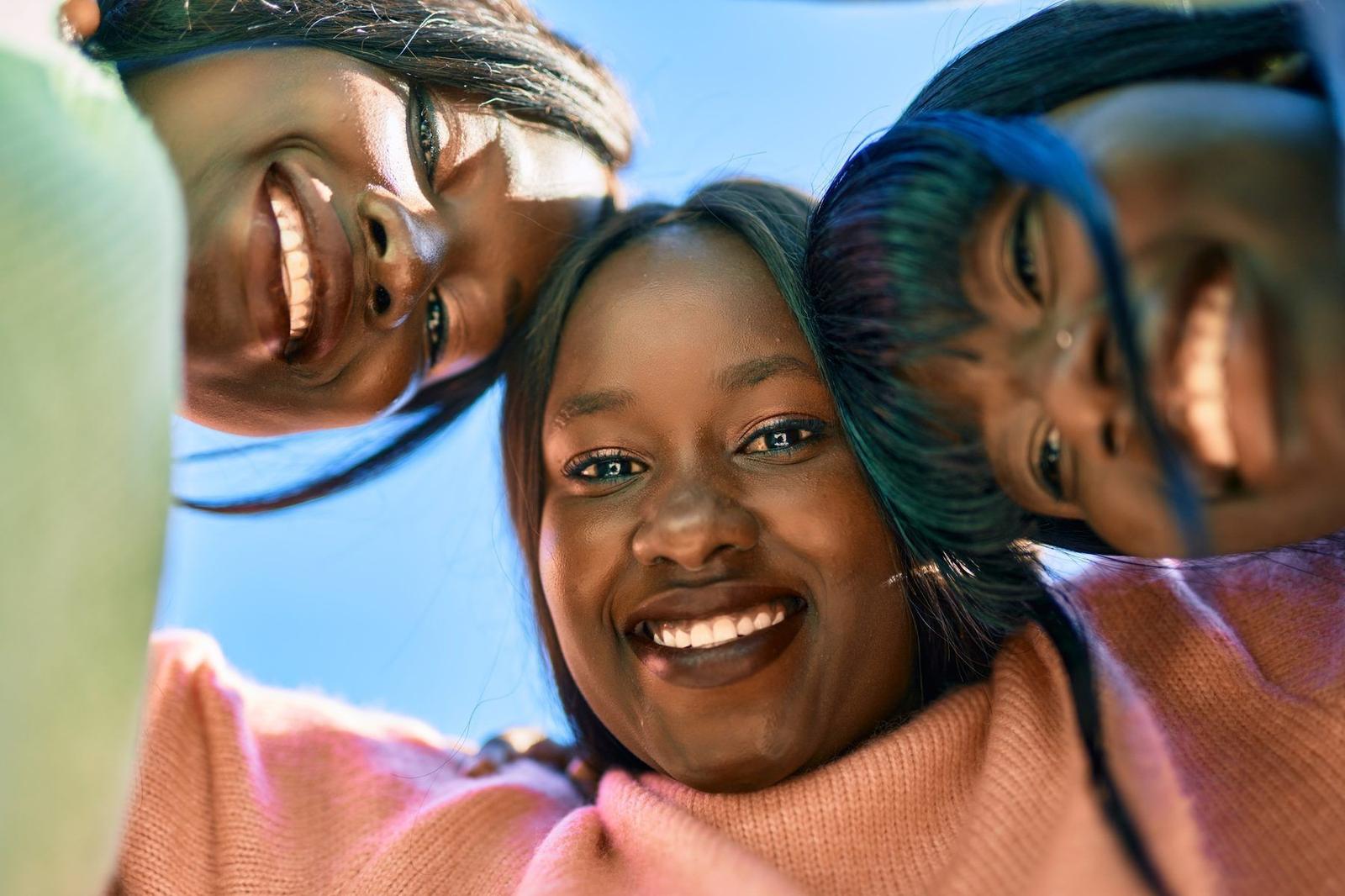 Three friends laughing together outdoors