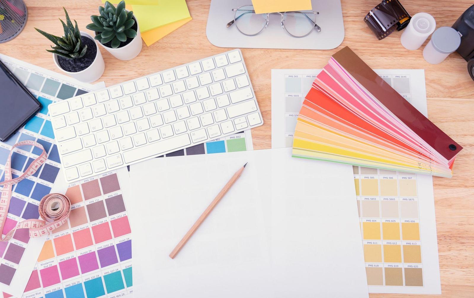 Colour swatches, sketches and a keyboard on a designer's desk