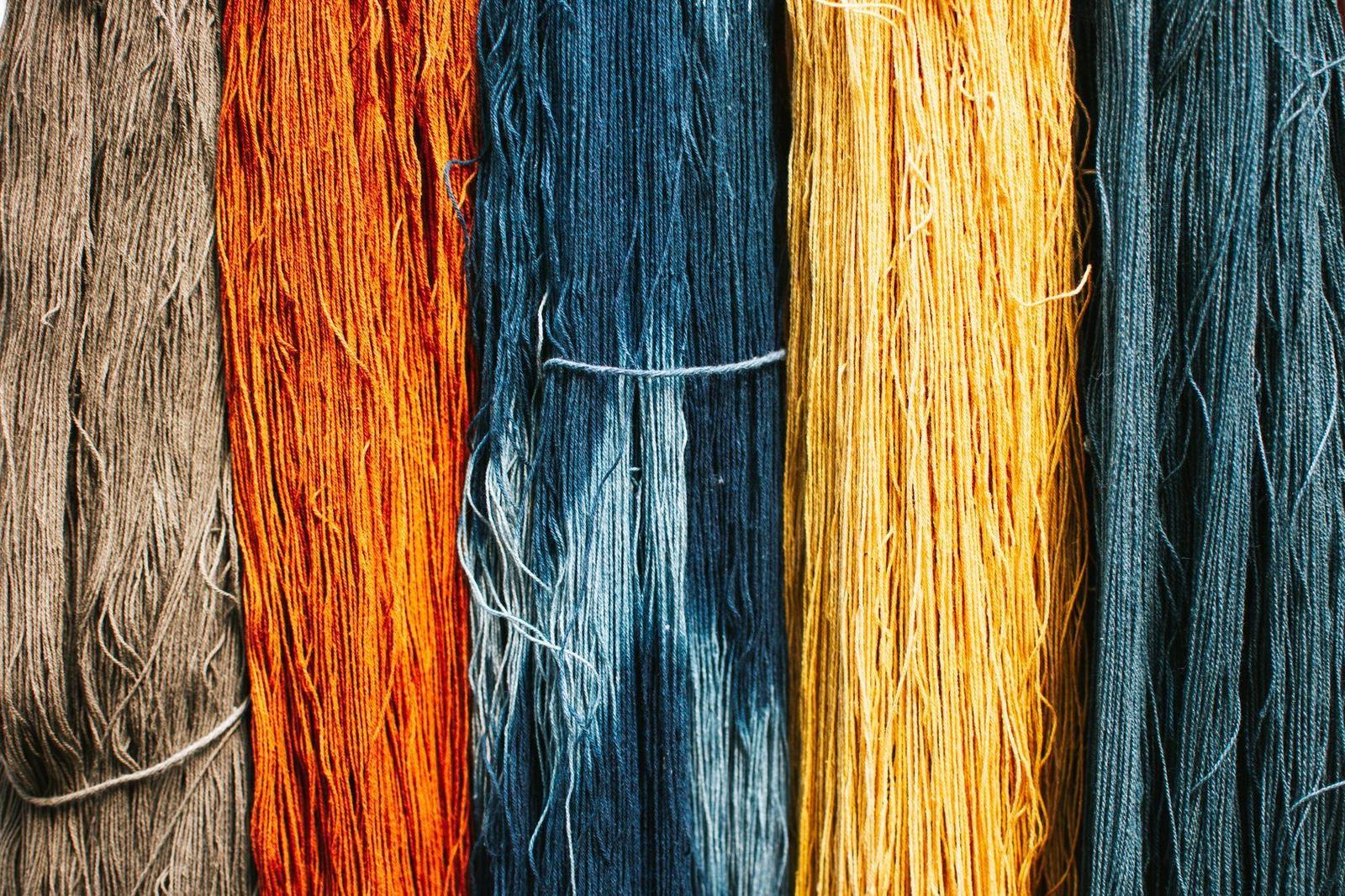 Hanks of dyed yarn in orange, blue and gold
