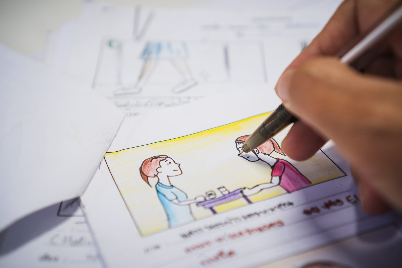 A hand sketching an animation storyboard