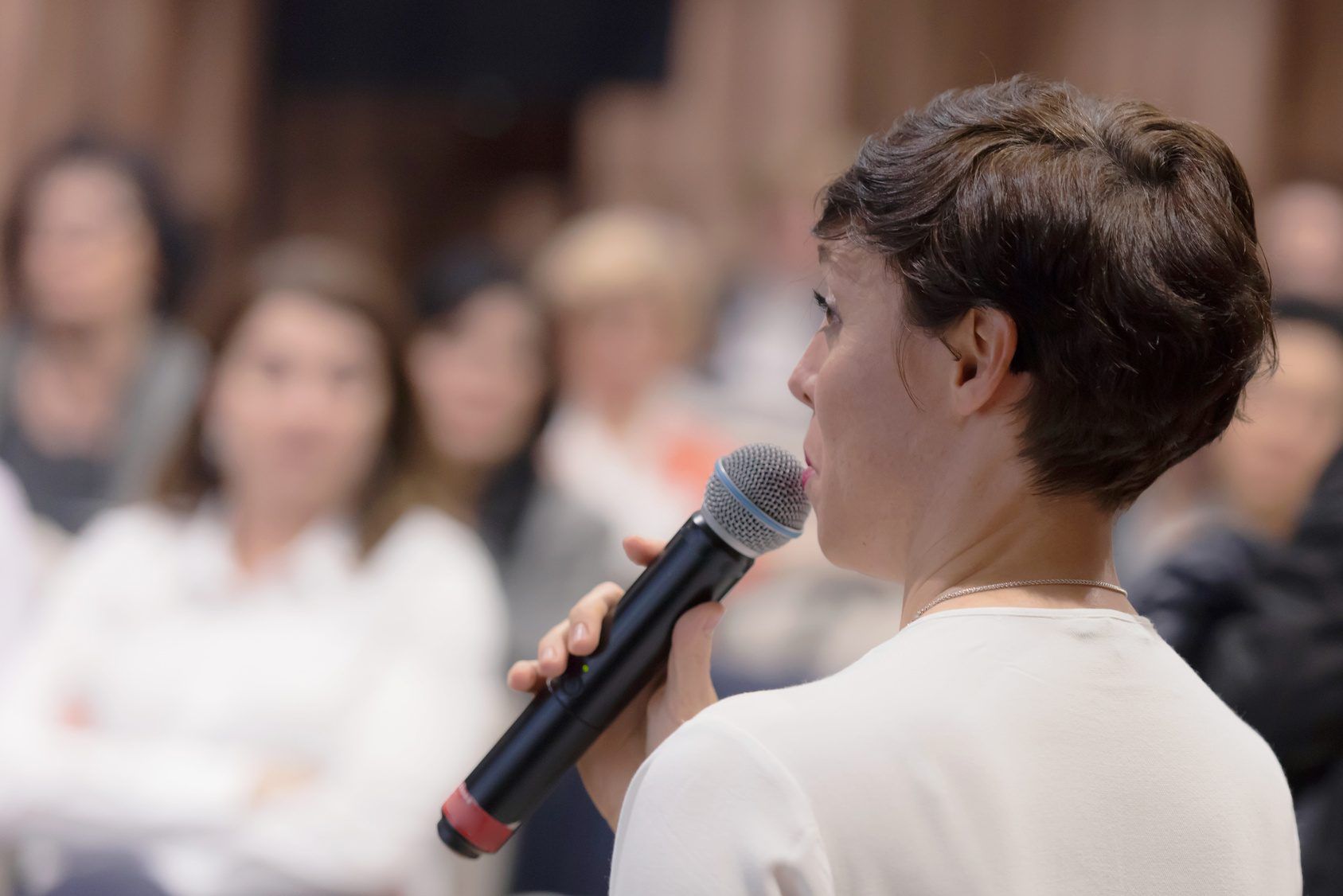 A young woman presenting to a small audience