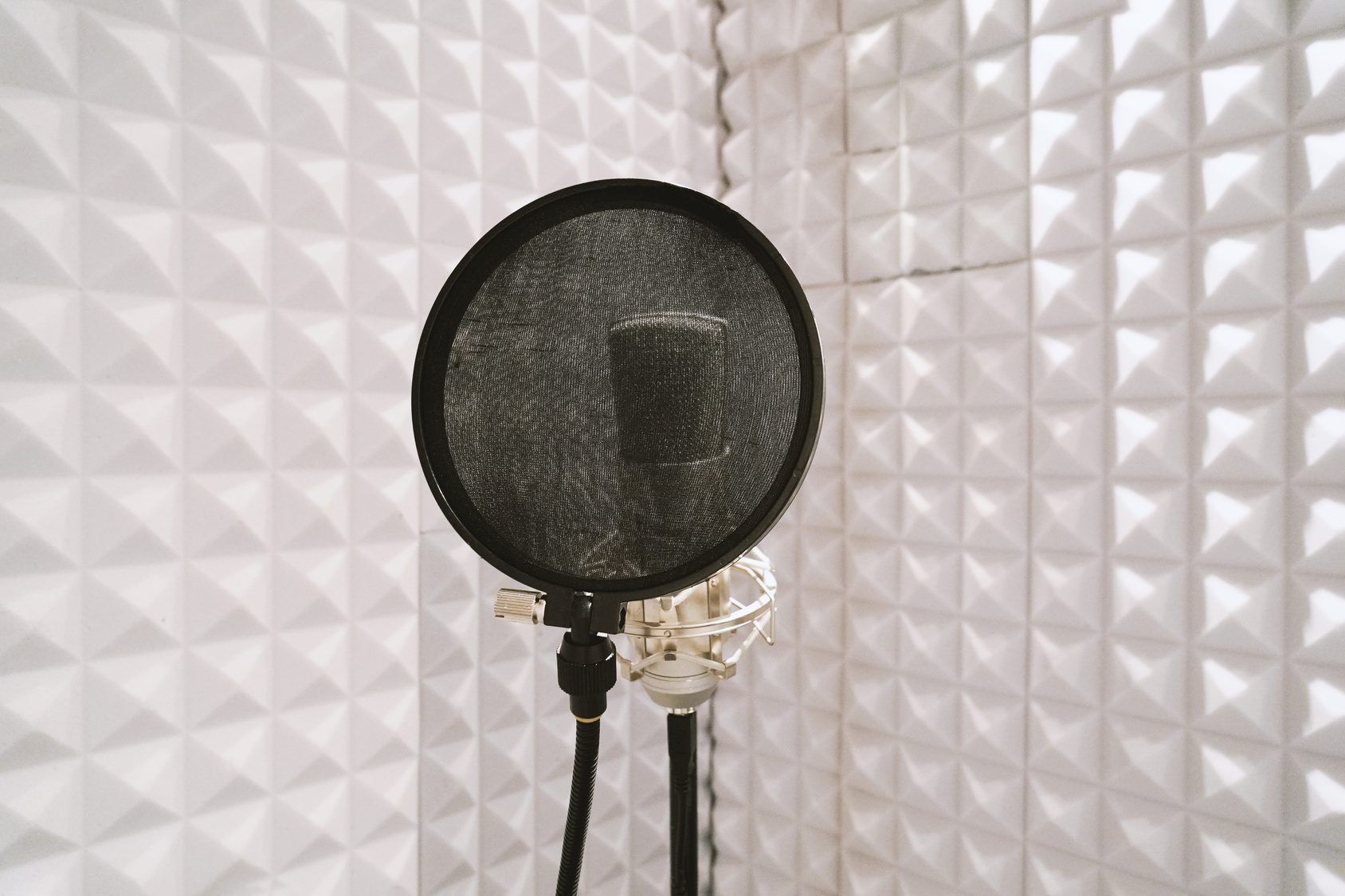 A voice artist recording at a studio microphone