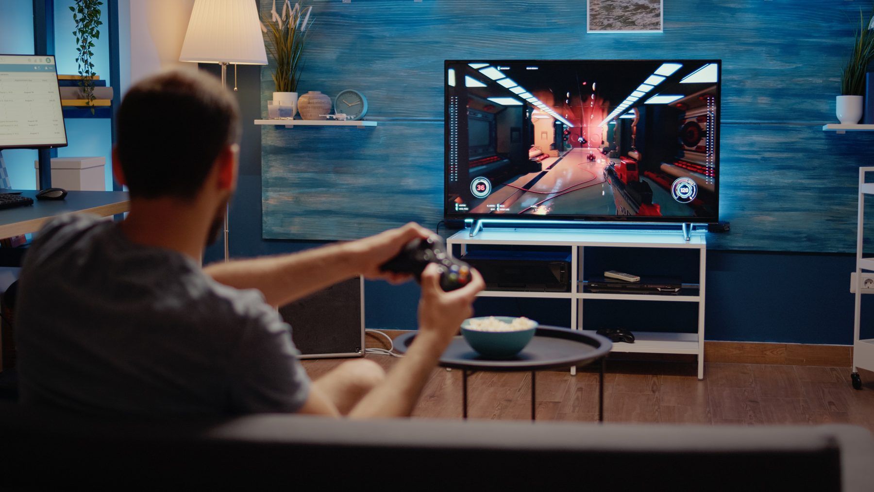 A player holding a controller in front of a video game on a TV