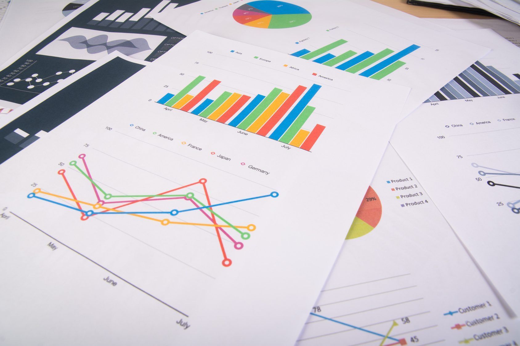 Printed charts and analysis spread across a desk